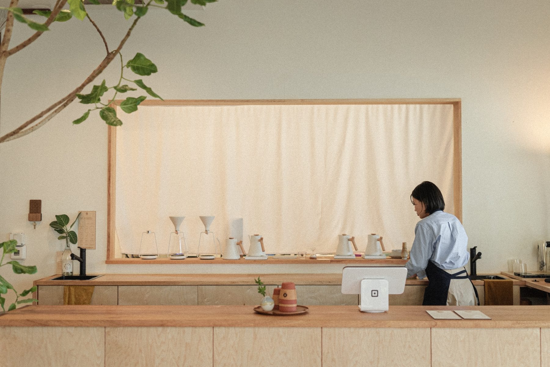 Hiromi preparing drinks behind the café counter