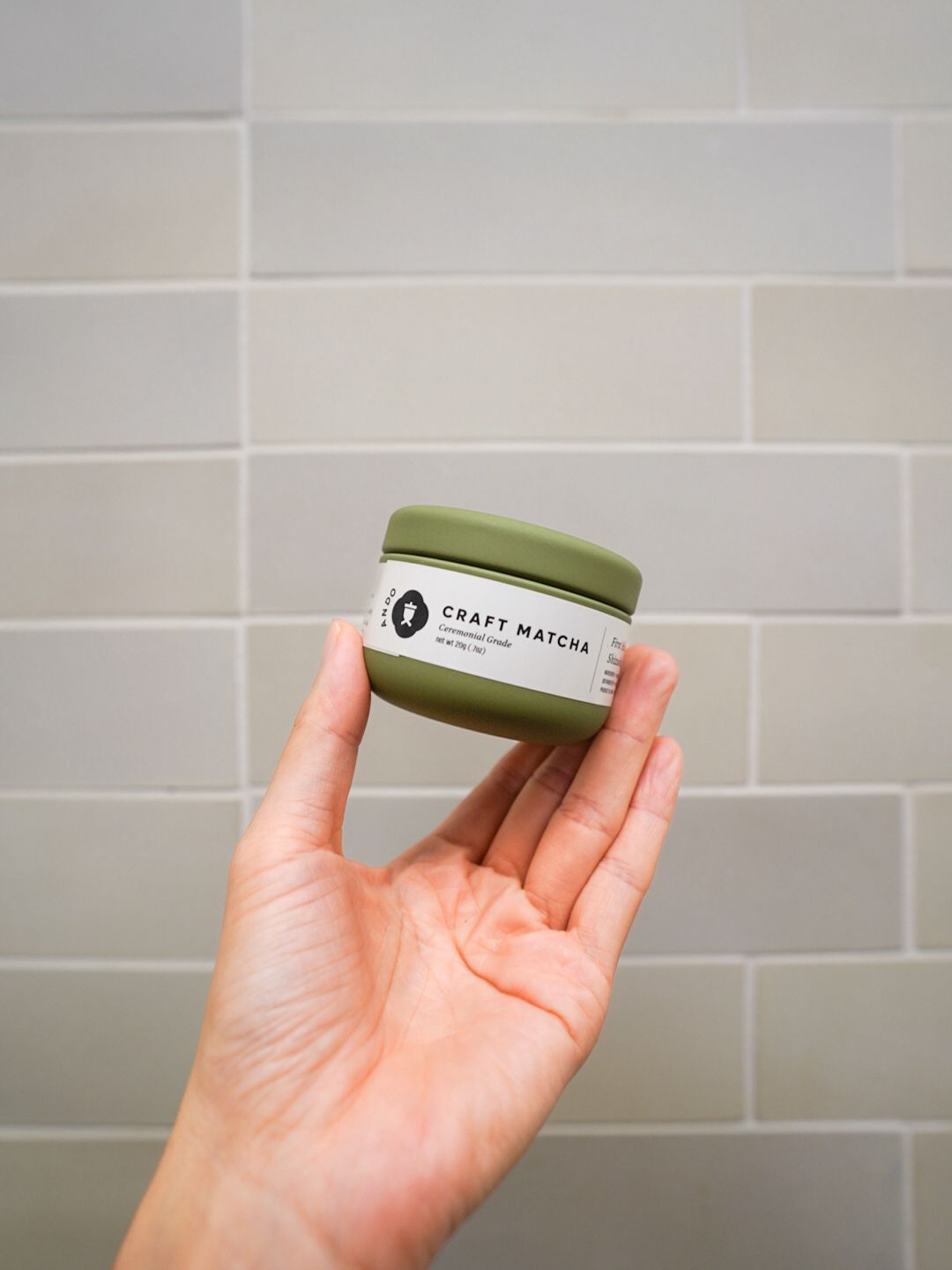 Hand holding an Ando Craft first-harvest Uji matcha tin